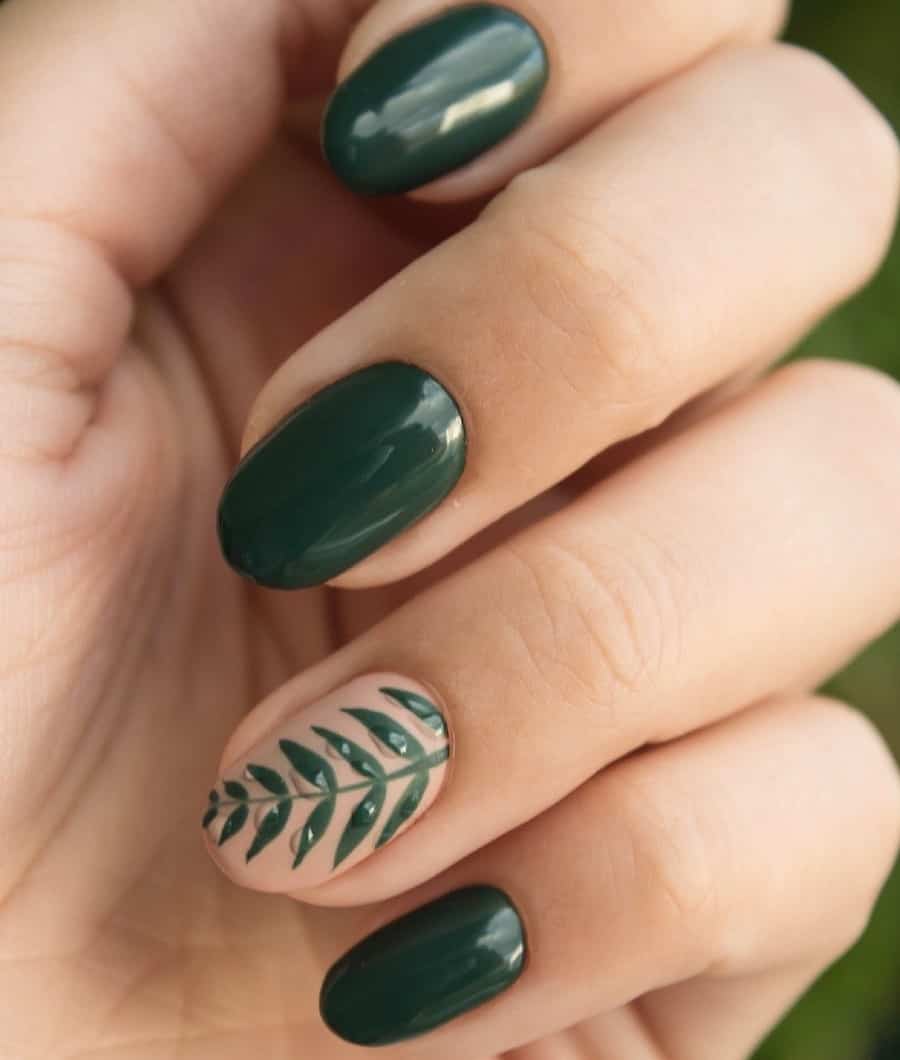 a hand with solid-colored dark green nails and one matte ɴuᴅᴇ accent nail with green leaf art