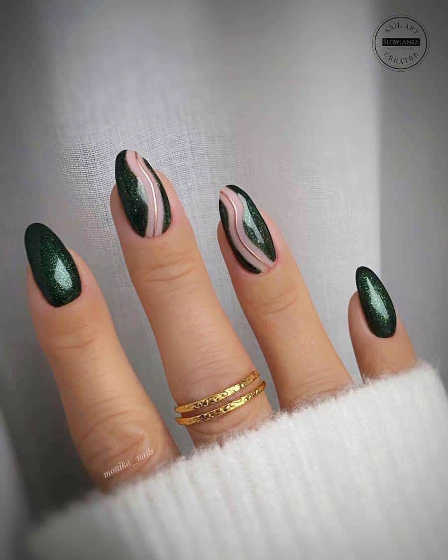 a hand with medium almond nails painted in a sparkly forest green shade with ɴuᴅᴇ and gold wave accents