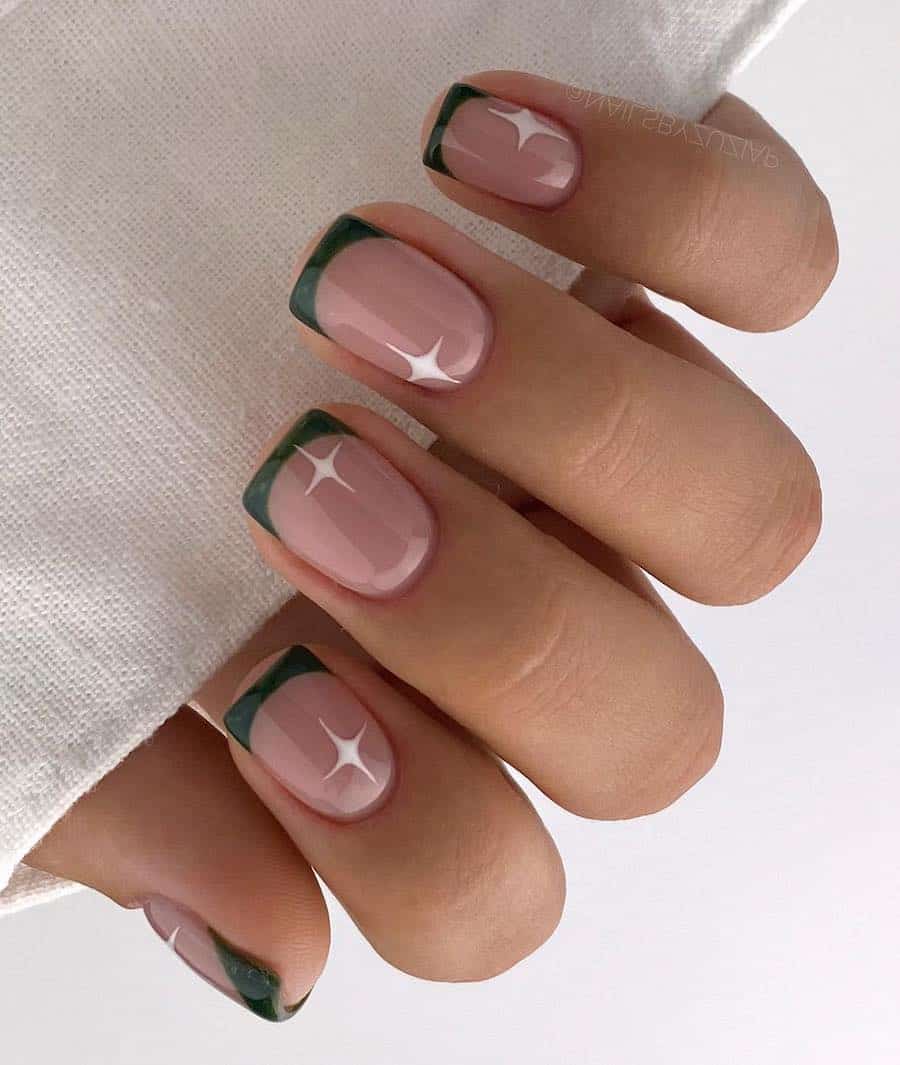 a hand with short square ɴuᴅᴇ nails with forest green French tips and white sparkle accents