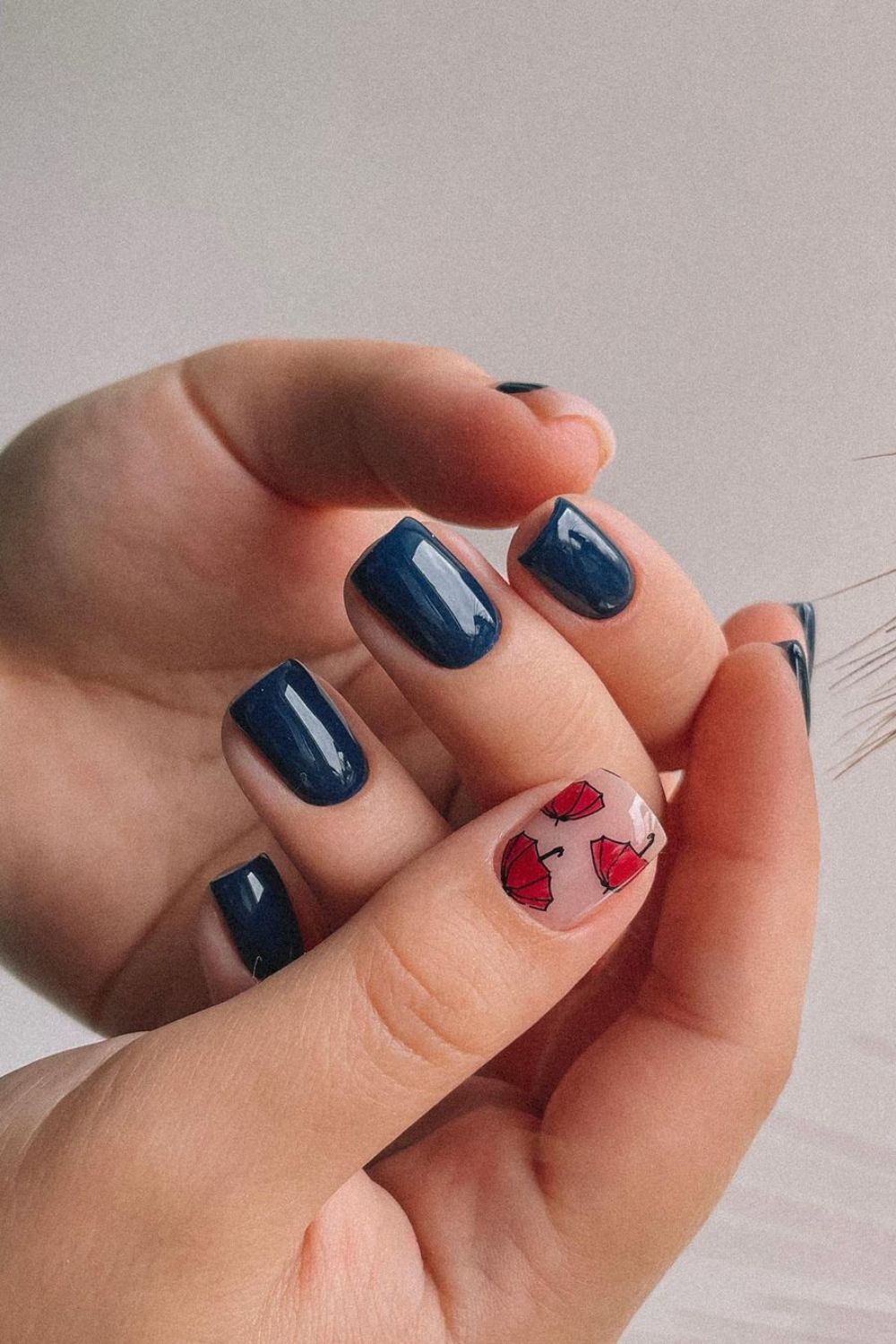 Dark blue nails with little red umbrellas