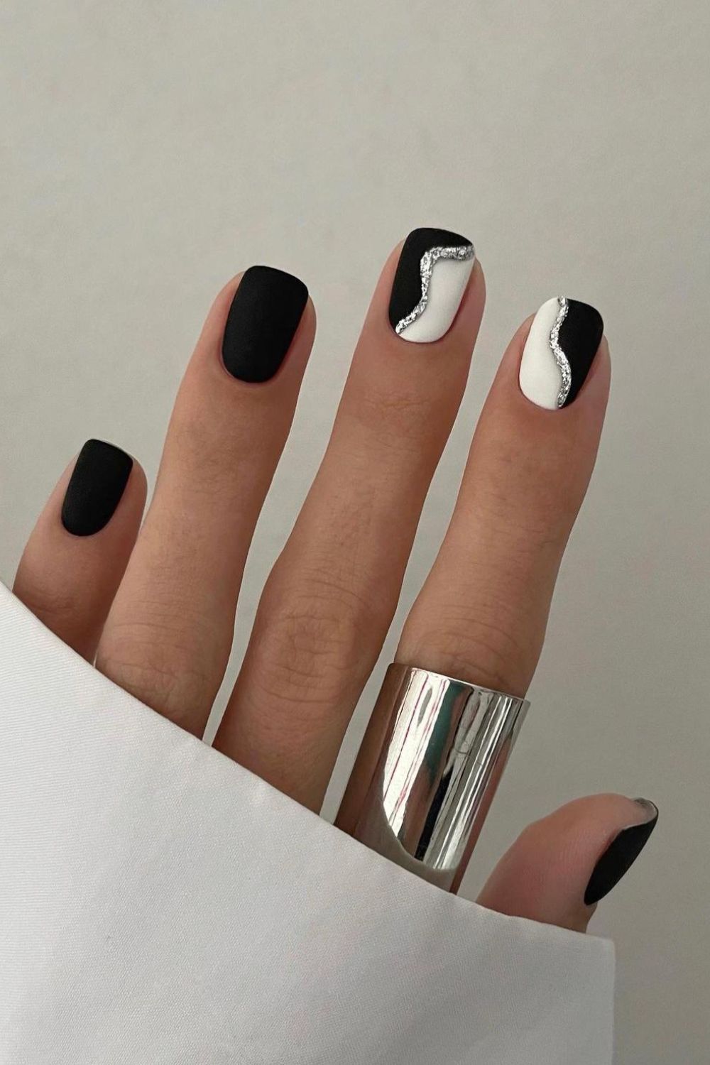 Black and white nails with silver glitter accent