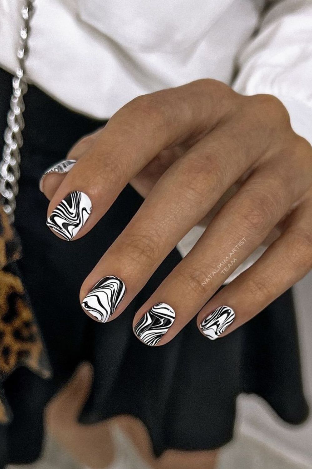 White nails with black marble swirl pattern