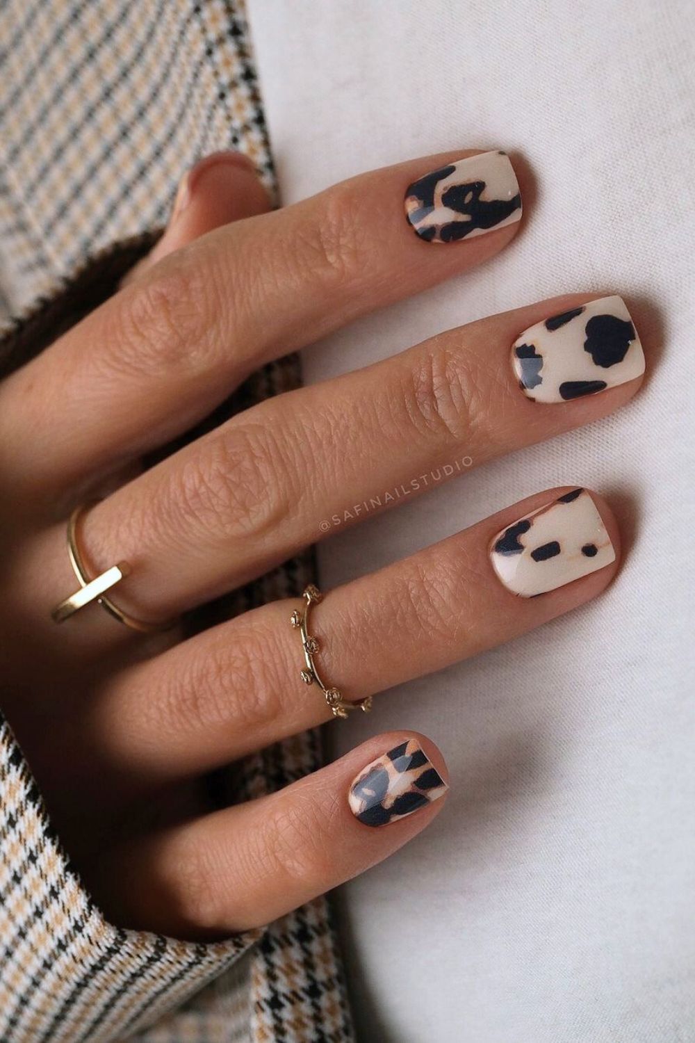 Creamy white nails with black cow print pattern